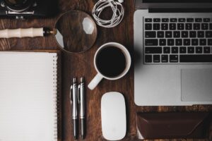 Thuiswerkplek met laptop en koffie waarvoor thuiswerkvergoeding geldt